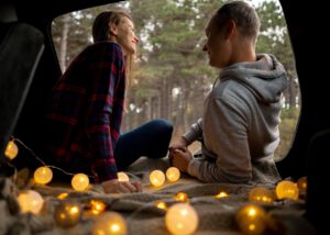 couple enjoying their date night in the van surrounded by lights 