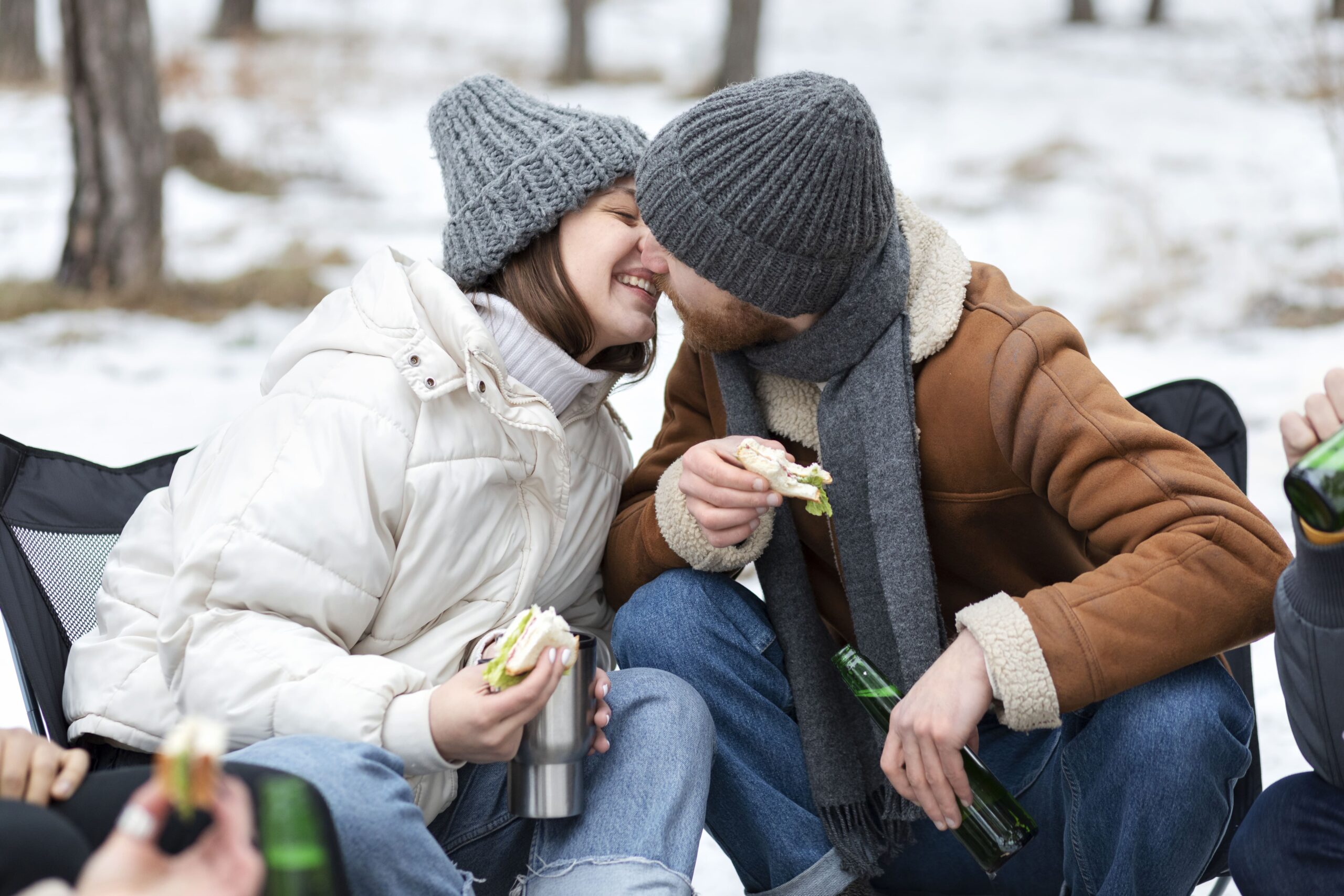 couple sharing a kiss while enjoying lunch outdoors